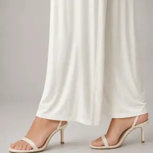 Off-white soft-drape wide-leg pants in viscose knit, styled with nude strappy heels – Lillithe