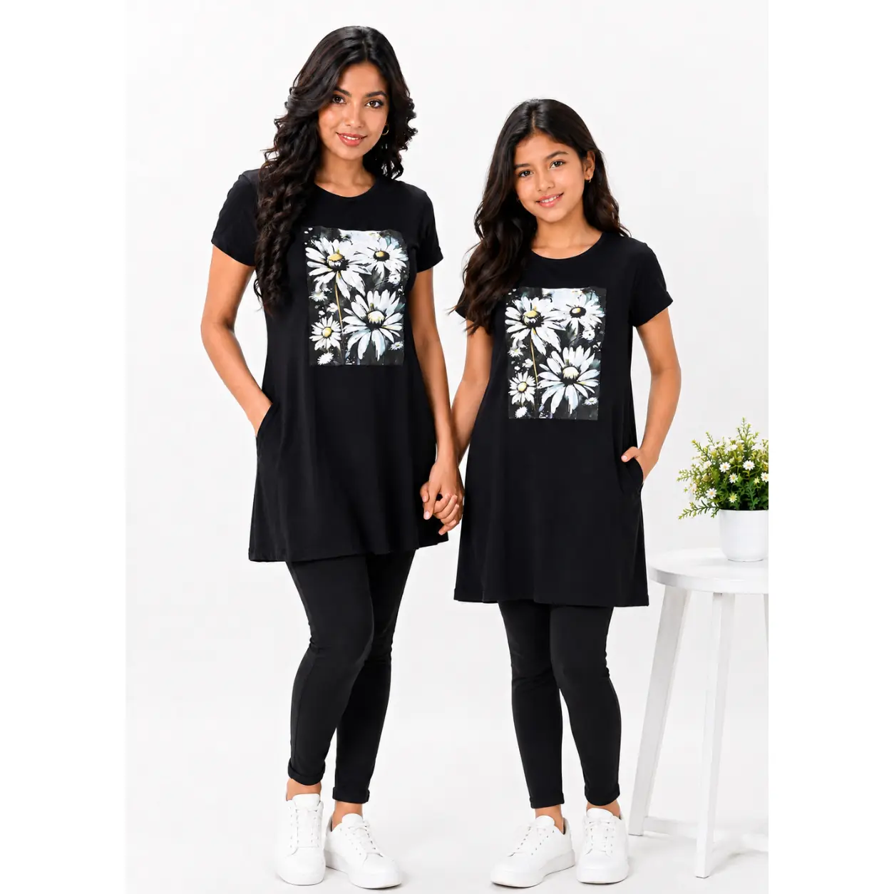 Model wearing Lillithe Essentials black long T-shirt with daisy floral print, paired with black leggings